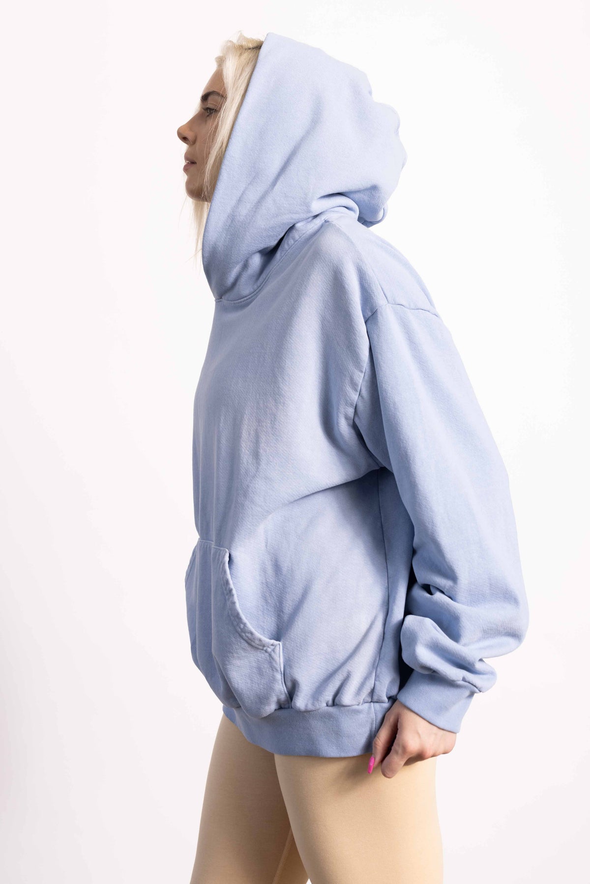 White blond female model with edgy style wearing a heavyweight cotton vintage green hoodie