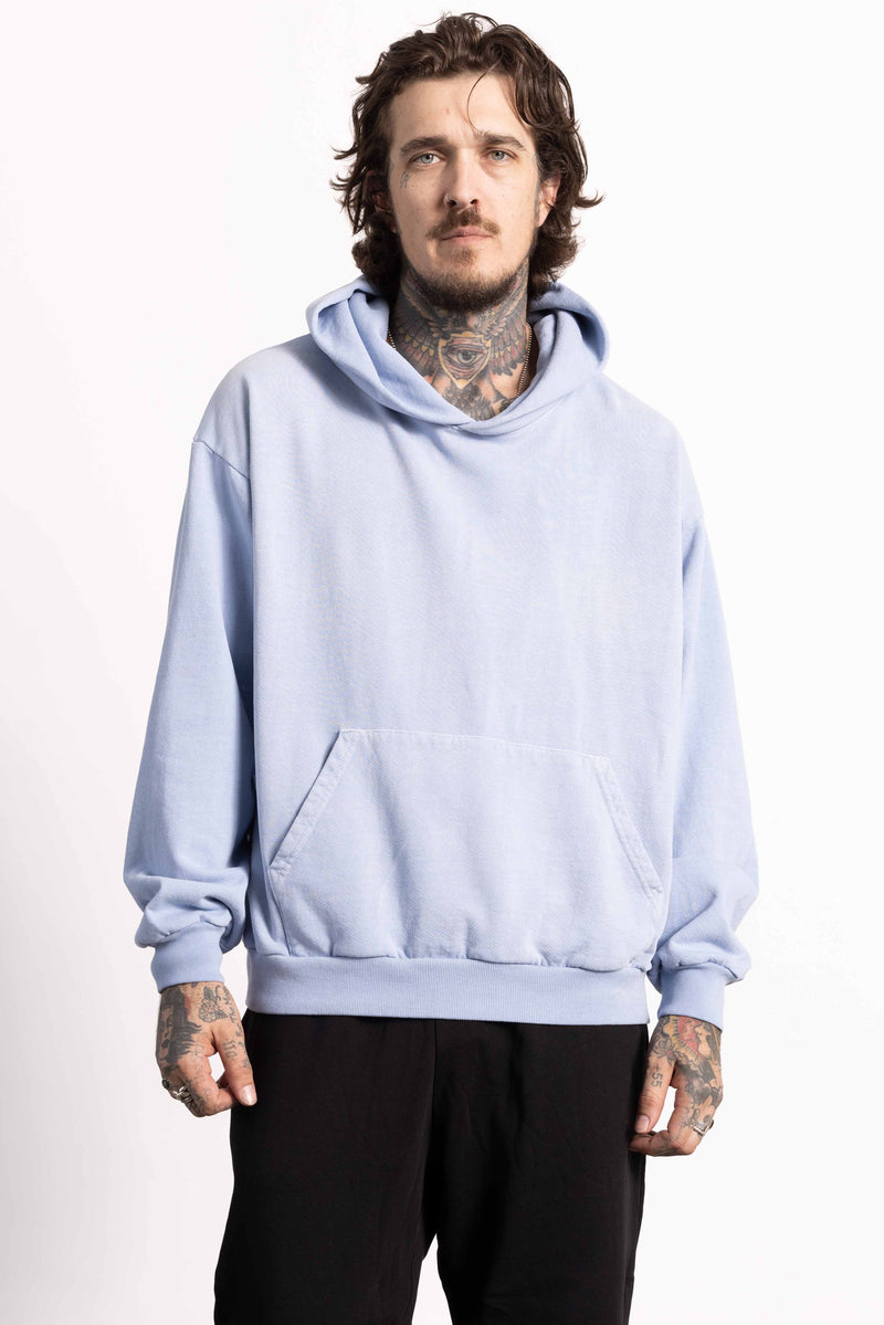 White male model with edgy style wearing a heavyweight cotton light blue hoodie