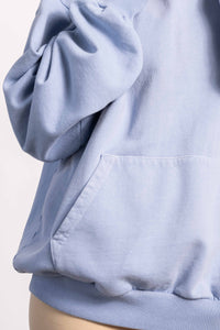 White blond female model with edgy style wearing a heavyweight cotton vintage green hoodie